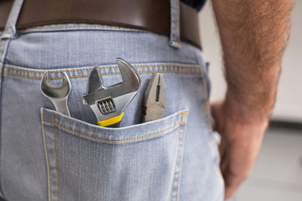 Handyman with tools in back pocket in the kitchen